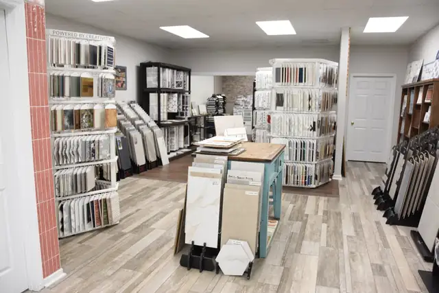 Inside the Preferred Tile showroom: racks of tile sample boards, display stands and a wood-look tile floor